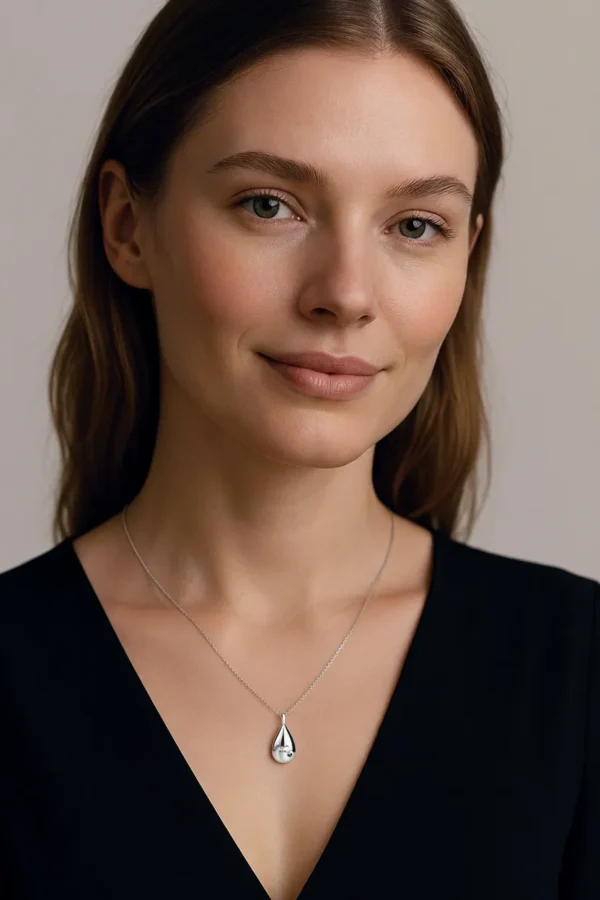 woman wearing silver teardrop urn necklace for ashes